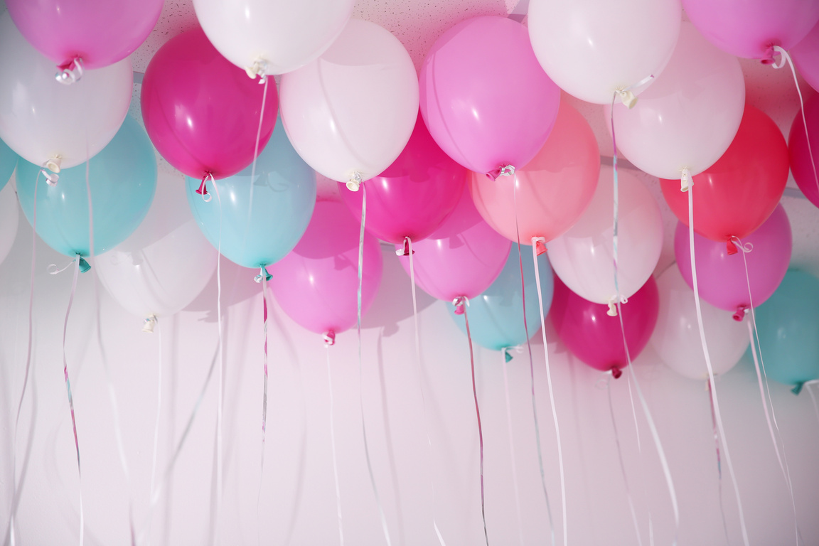 Pink and Turquoise Balloons Floating on the Ceiling Up Close